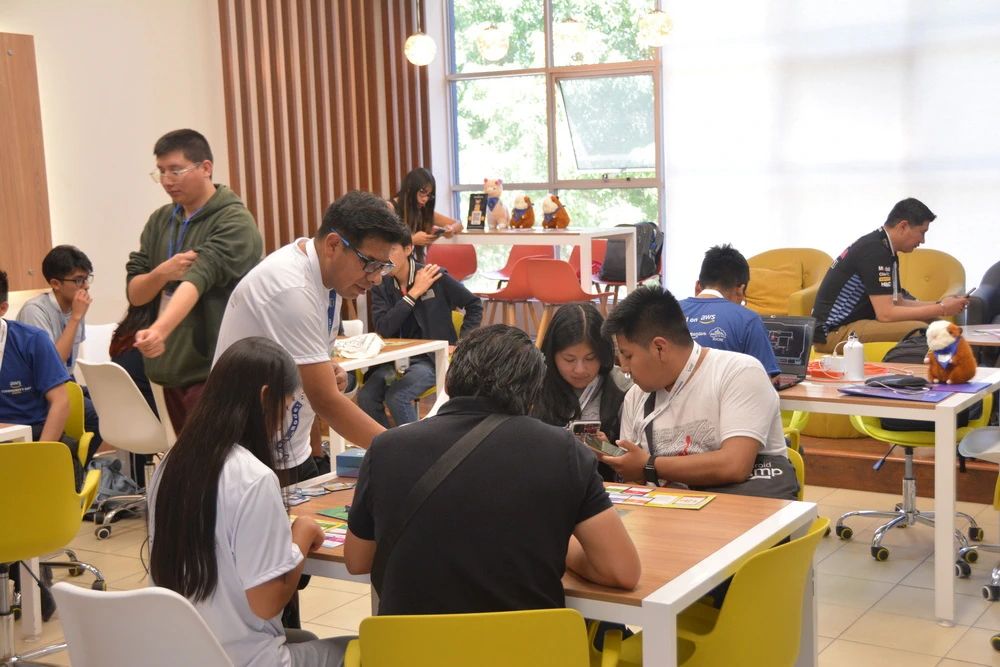 Participantes trabajando en grupos durante un taller de AWS Community Day Bolivia